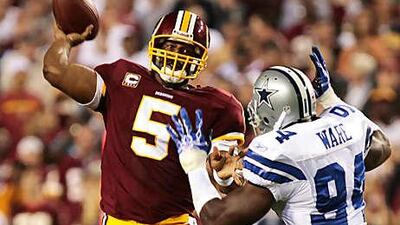 The Washington Redskins quarterback Donovan McNabb is pressured by the Dallas Cowboys linebacker DeMarcus Ware.