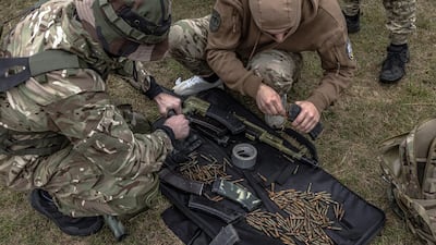Volunteer fighters preparing weapons for training exercises near Kyiv. EPA