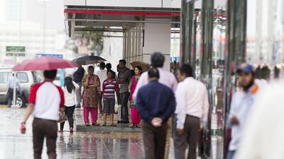 People take shelter along Fatima bint Mubarak street in Abu Dhabi. Christopher Pike / The National