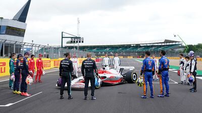 Drivers gather around a model of the 2022 F1 car.