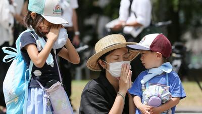 A family offers a silent prayer for the atomic bomb victims at Nagasaki Hypocenter Park to mark the 75th anniversary of the atomic bombing of the city. AFP