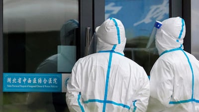 Staff members in protective suits stand at Hubei Provincial Hospital of Integrated Chinese and Western Medicine where members of the World Health Organisation (WHO) team tasked with investigating the origins of the coronavirus disease (COVID-19) are visiting, in Wuhan, Hubei province, China. Reuters