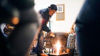 Medicine Man Herbert Wilson, a citizen of the Dine, or Navajo Nation, lights the ceremonial fire for the cleansing ceremony he led in Carpenter Hall at Dartmouth College. AP