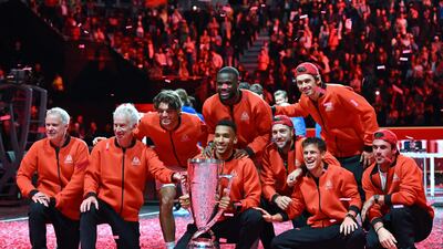 Team World (L-R) vice captain Patrick McEnroe, captain John McEnroe, USA's Taylor Fritz, Canada's Felix Auger-Aliassime, USA's Frances Tiafoe, USA's Jack Sock, Australia's Alex De Minaur, Argentina's Diego Schwartzman and USA's Tommy Paul pose with the trophy on the court after victory. AFP