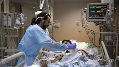 An Israeli medic tends to a wounded young Syrian young boy at Ziv Hospital, which perches on a rocky hilltop in the upper Galilee town of Safed. Patients are transferred there from the emergency field clinic whose controversial funding has is likely to cost UK cabinet minister Priti Patel her job. Menahem Kahana / AFP
