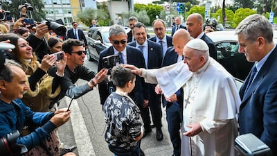 Pope Francis blesses a boy after leaving the Gemelli hospital in Rome, where he was treated for bronchitis. AFP