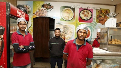 Cooks and waiters pose at the Zaiqa restaurant in southern suburbs of Doha on March 31. AFP Photo