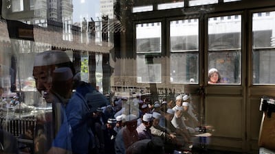 People are reflected in windows as they sit before attending prayers at Niujie mosque in Beijing, China. Jason Lee / Reuters