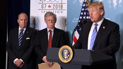 Director of the US National Economic Council National Larry Kudlow, left, and Security Adviser John Bolton listen as US President Donald Trump speaks to reporters at the G7 Summit in La Malbaie, Quebec. Saul Loeb / AFP