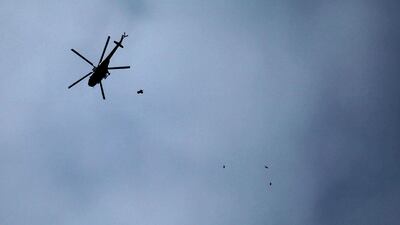 A picture taken on February 20, 2018 shows a Russian-made Syrian army attack helicopter dropping a payload over a rebel-held town in Syria. Amer Al Mohibany / AFP