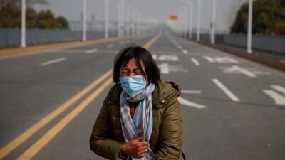A mother reacts as she pleads with police to allow her daughter to pass a checkpoint for cancer treatment after she arrived from Hubei province at the Jiujiang Yangtze River Bridge in Jiujiang, Jiangxi province, China, as the country is hit by an outbreak of a new coronavirus, February 1, 2020. Reuters