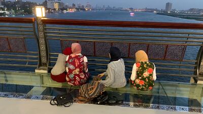 Young Egyptian women sitting on a bridge on the outskirts of Cairo. Hamza Hendawi / The National