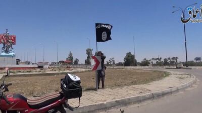 A video frame showing an ISIL fighter hanging a flag in Ramadi, the capital of Anbar province. (AAMAQ / AFP)