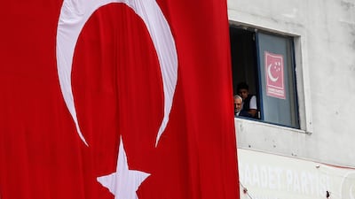A Turkish flag hangs from a building during an election rally of Turkey's President Recep Tayyip Erdogan and his ruling Justice and Development Party, or AKP, in Istanbul, Turkey, on June 23, 2018. Lefteris Pitarakis / AP Photo