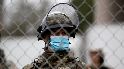 A member of the Washington State National Guard stands behind security fence outside the Washington State Capitol Building, as the 2021 Legislative session begins in Olympia, Washington. Reuters