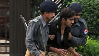 Pakistani policemen help an injured colleague after a suicide attack near the Red Mosque.
