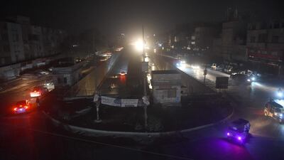 Motorists drive through a residential area during a power blackout in Pakistan's port city of Karachi. AFP