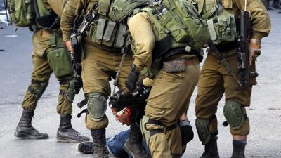 Israeli soldiers arrest a Palestinian for reportedly throwing stones at Israeli settlers and Jews during a religious procession in the West Bank city of Hebron on November 11, 2017. Hazem Bader / AFP