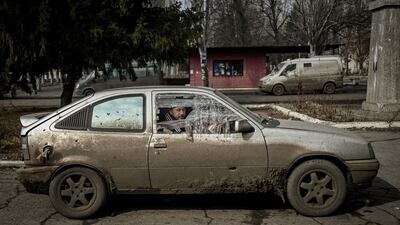 A man sits inside a damaged car in the village of Chasiv Yar. AFP