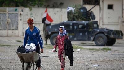 Displaced Iraqis walk through Mosul's Al Tayaran neighbourhood after fleeing the Old City on April 8. / AFP / AHMAD GHARABLI