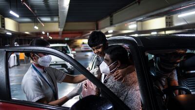 Children watch their father getting inoculated during a drive in facility for Covid-19 vaccination at the Lulu shopping mall in Kochi, Kerala. AP