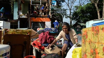 An “informal settler” gathers her belongings as workers demolish her house in Manila on January 27, 2014. Hundreds of the settlers' quarters were demolished by local government authorities to make way for a commercial development. Ted Aljibe / AFP photo