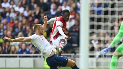 Arsenal's English striker Folarin Balogun shoots past Tottenham Hotspur's English defender Eric Dier.