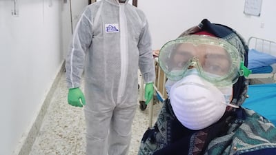 Farah Al-Awadi, a 28-year-old Iraqi woman who has contracted coronavirus disease, takes selfies with a member of the medical team during quarantine in the holy city of Najaf, Iraq. Reuters
