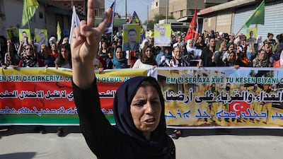 Kurdish and Arab protesters chant slogans against Turkish President Tayip Erdogan as they walk during a march to the United Nations Headquarters in the town of Qamishli, Syria. REUTERS