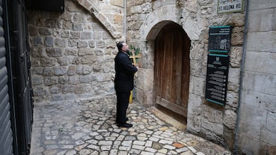 A Palestinian Christian, carrying a cross and a palm frond, found the doors of the Church of the Holy Sepulchre locked on Palm Sunday. Reuters