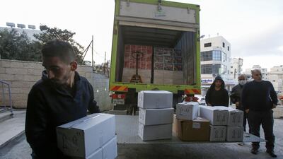 Palestinian workers unload food supplies to deliver to a hotel under quarantine in the West Bank city of Bethlehem on March 7, 2020, a day after a lockdown on the biblical city was announced upon discovering the first Palestinian cases of the disease. AFP