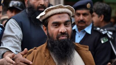 In this photograph taken on January 1, 2015, Pakistani security personnel escort Zaki-ur-Rehman Lakhvi alleged mastermind of the 2008 Mumbai attacks, as he leaves the court after a hearing in Islamabad. AFP Photo