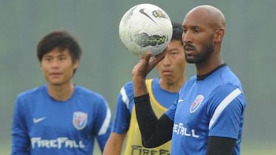 Shanghai Shenhua's French football player Nicolas Anelka poses with a Chinese immigration officer on his arrival at the Shanghai Pudong airport in China..