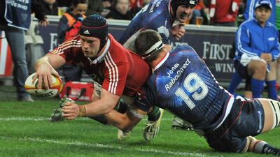 Sean O'Brien, left, of the Lions, leaps over the try line to score. Paul Crock / AFP