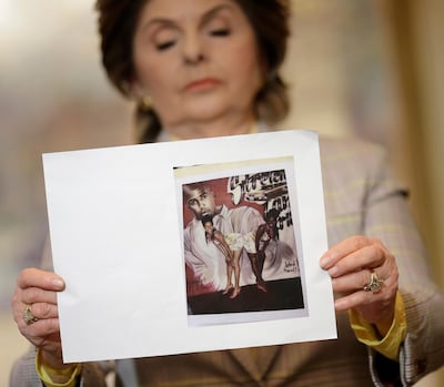 Attorney Gloria Allred holds up a picture of two girls posing in front of a picture of R Kelly, on the night they claim they became victims of his sexual advances. AP