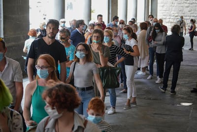 Visitors queue outside, waiting to go inside on the reopening day of the Uffizi museum in Florence, Italy. AP Photo