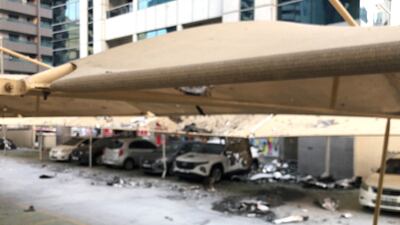 Burnt debris scattered across cars and a parking area. Nicholas Webster / The National