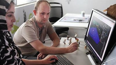 Matthew Bell, head lecturer at twofour54's Gaming Academy, helps a student. The academy was set up with French developer Ubisoft, which is responsible for titles such as Assassin's Creed. Delores Johnson / The National