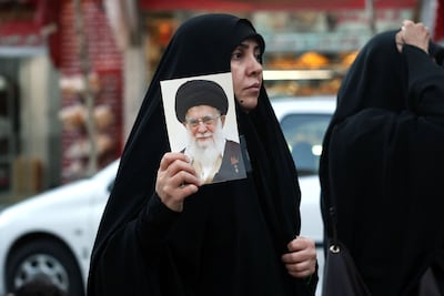 An Iranian woman holds an image of assassinated supreme leader Ayatollah Ali Khamenei in Tehran. AFP