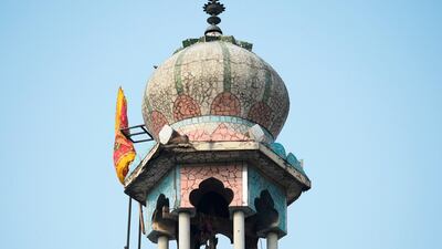 A Hindu religious flag is seen on a minaret of a burnt-out mosque following the clashes. AFP