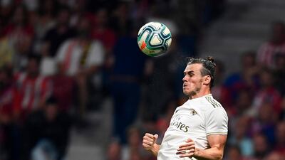 Real Madrid's Welsh forward Gareth Bale jumps for the ball during the Spanish league football match between Club Atletico de Madrid and Real Madrid CF at the Wanda Metropolitano stadium in Madrid on September 28, 2019. / AFP / OSCAR DEL POZO