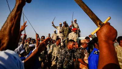 Mohamed Hamdan Dagalo (C-R), also known as Himediti, deputy head of Sudan's ruling Transitional Military Council (TMC) and commander of the Rapid Support Forces (RSF) paramilitaries, waves a baton as he rides in the back of a vehicle surrounded by RSF members and crowds of supporters in the village of Qarri, about 90 kilometres north of Khartoum. AFP