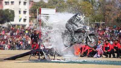 A Jammu and Kashmir state policeman performs a motorcycle stunt during Republic Day celebrations in Jammu, India. AP