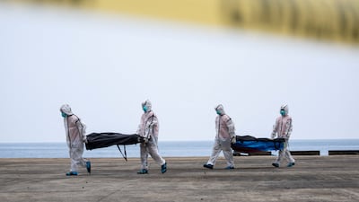 Members of the Philippine Coast Guard carry body bags containing the remains of victims following a fire aboard the MV June Aster ferry, off the coast of Palawan, in Coron. Reuters