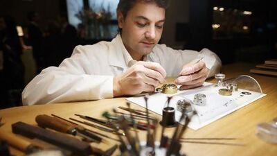 A watchmaker demonstrates how to assemble a watch at the Audemars Piguet booth. Valentin Flaurad / Bloomberg