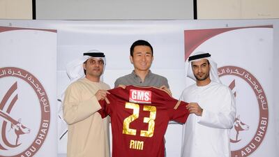 Al Wahda's new signing Rim Chang-woo, centre, poses with Dr Jamal Al Hosani and team manager Abdul Basit Mohammed at the Al Nahyan Stadium on Friday. Courtesy Al Wahda Club