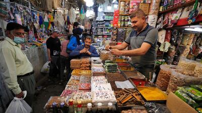 An Iraqi man sells food at the Shorja market in central Baghdad on April 12, 2021 ahead of the Muslim holy month of Ramadan after the easing of the curfew imposed by authorities amid the coronavirus COVID-19 pandemic. / AFP / AHMAD AL-RUBAYE