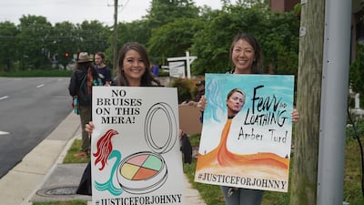 Two fans of Depp hold signs showing their support outside the courthouse. Willy Lowry / The National