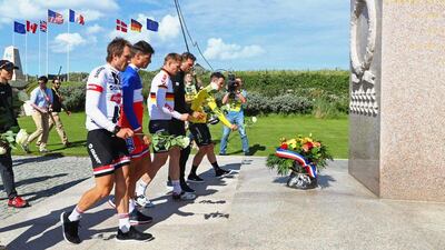 Stage winner Mark Cavendish of Great Britain and Team Dimension Data (R) and fellow riders place flowers at a war memorial at Utah Beach after Stage 1 of Le Tour de France 2016 on July 2, 2016 in Sainte-Marie-du-Mont, France. Michael Steele / Getty Images