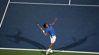 Djokovic serves to Federer during their Dubai Duty Free Tennis Championships final. Karim Sahib / AFP